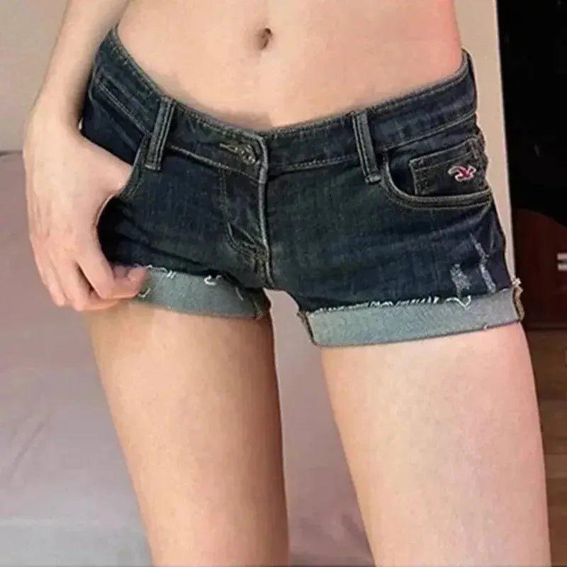 Women's dark denim shorts with rolled hem and distressed details, fashion style