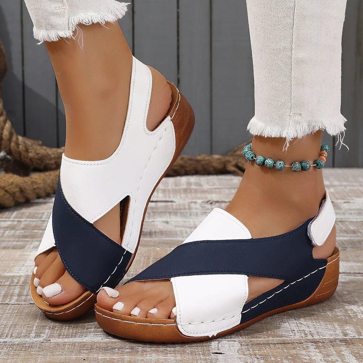 White and navy blue women's wedge sandals with crisscross straps, perfect for summer fashion.