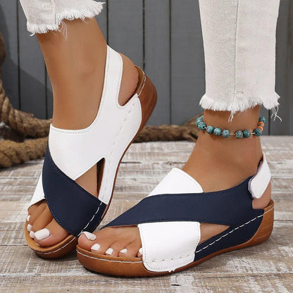White and navy blue women's wedge sandals with crisscross straps, perfect for summer fashion.