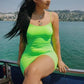Woman in neon green ruched dress on boat by lake, summer fashion outfit