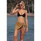 Woman in black bikini top and tan sarong skirt by beach, stylish summer swimwear fashion