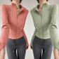 Women's zip-up athletic jackets in pink and green, paired with gray leggings for fitness fashion