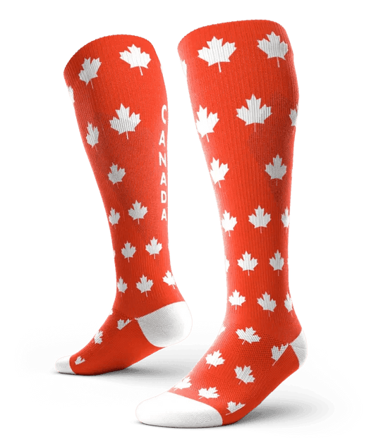 Red knee-high socks with white maple leaves and 'CANADA' text, fashion accessory for women