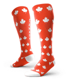 Red knee-high socks with white maple leaves and 'CANADA' text, fashion accessory for women