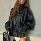 Woman in black leather jacket, lace skirt, oversized sunglasses, holding black handbag, fashion style
