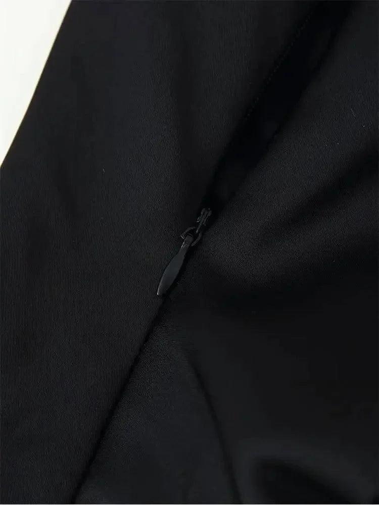 Black women's fashion garment with hidden zipper detail, sleek fabric texture