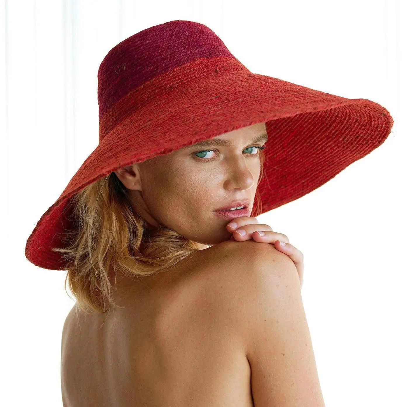 Woman wearing stylish red wide-brimmed sun hat, perfect for summer fashion and beach looks