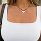 Woman wearing white square neck top with silver heart pendant necklace, fashion jewelry