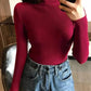 Woman wearing burgundy ribbed turtleneck sweater with high-waisted jeans, casual fashion outfit