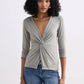 Woman wearing olive green twist-front long sleeve top with jeans, stylish fashion outfit
