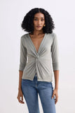 Woman wearing olive green twist-front long sleeve top with jeans, stylish fashion outfit