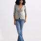 Woman in olive green twist-front top, blue flare jeans, and beige loafers for stylish fashion look
