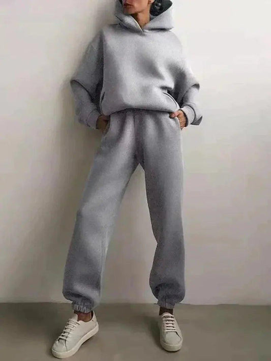 Gray women's hoodie and jogger set with white sneakers, casual fashion outfit