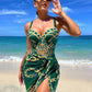 Woman in green chain-print beach dress with high slit, sunglasses, ocean backdrop — summer fashion