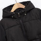 Black puffer jacket with hood and drawstring, women's winter fashion outerwear on hanger