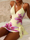 Woman in floral print yellow swimsuit with side tie, beach setting, fashion swimwear