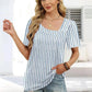 Woman in blue and white striped top with puff sleeves and distressed denim shorts