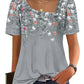 Women's gray floral print top with puff sleeves, square neckline, and front buttons, paired with jeans.