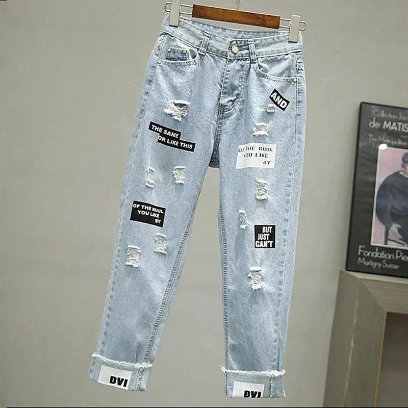 Light blue ripped jeans with text patches, cuffed hems, and distressed details for women's fashion