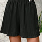Black pleated high-waist women's shorts with elastic waistband, fashion summer wear
