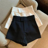 Black and white high-waisted women's fashion shorts on cozy sofa