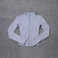 Light gray women's zip-up athletic jacket on textured gray background