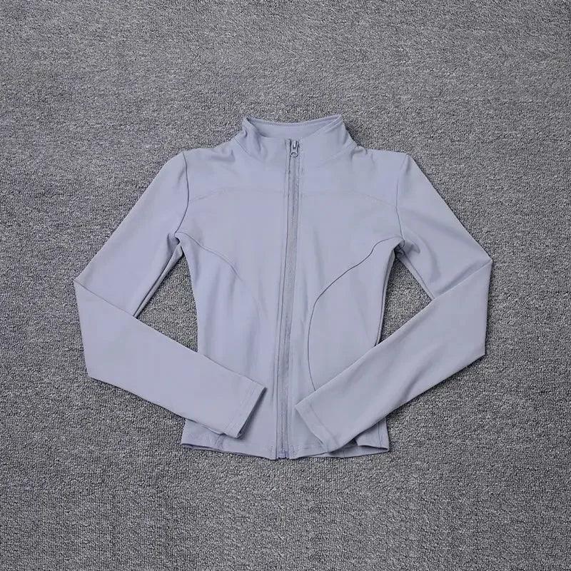 Light gray women's zip-up athletic jacket on textured gray background