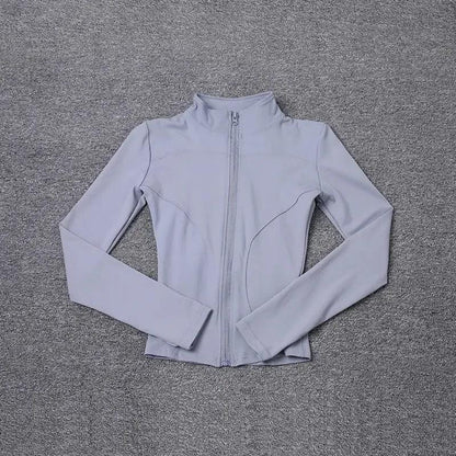 Light gray women's zip-up athletic jacket on textured gray background