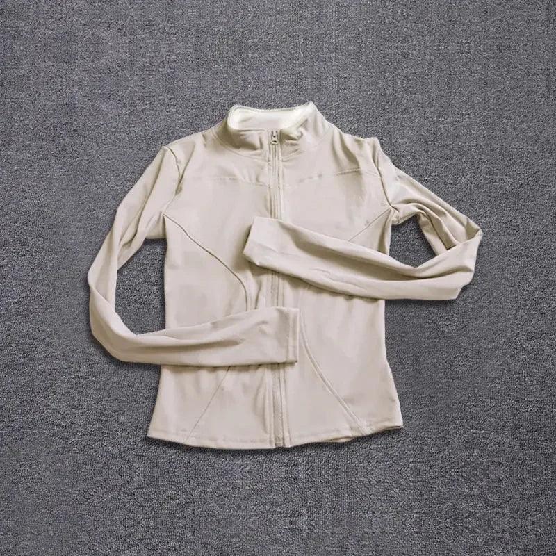 Beige women's long sleeve zip-up athletic jacket on gray background