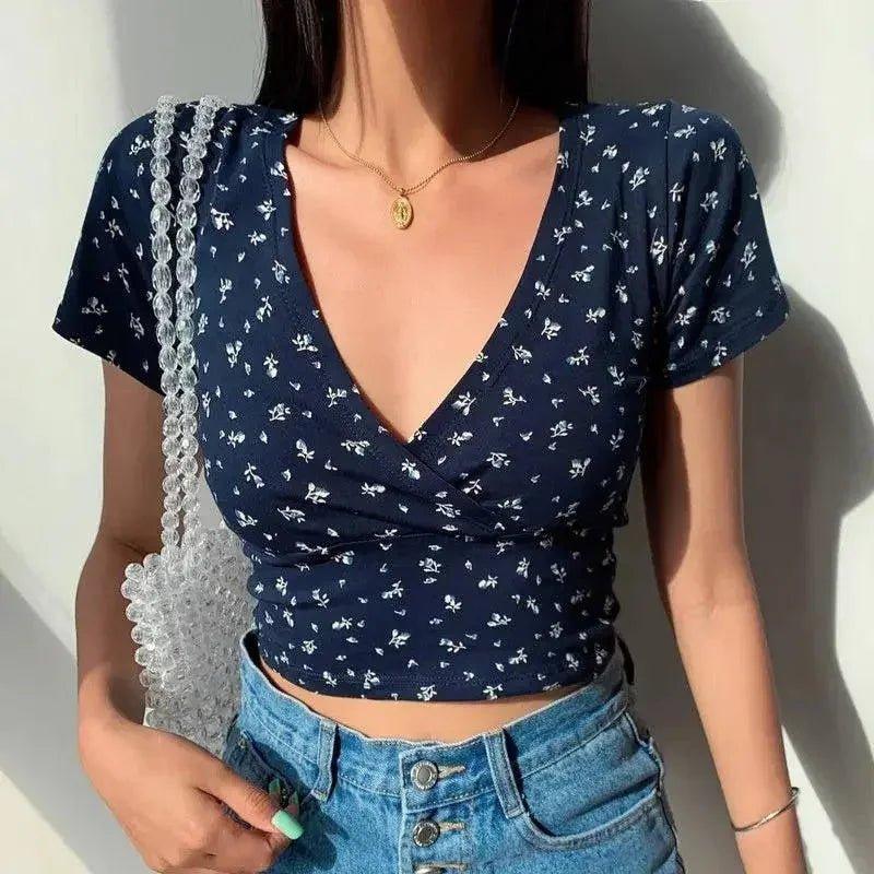 Navy floral wrap crop top with V-neck, paired with high-waist denim shorts and clear beaded bag