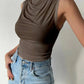 Woman wearing olive green sleeveless cowl neck top with light wash jeans, fashion outfit
