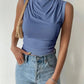 Woman wearing blue sleeveless cowl neck top with high waist jeans, stylish fashion outfit