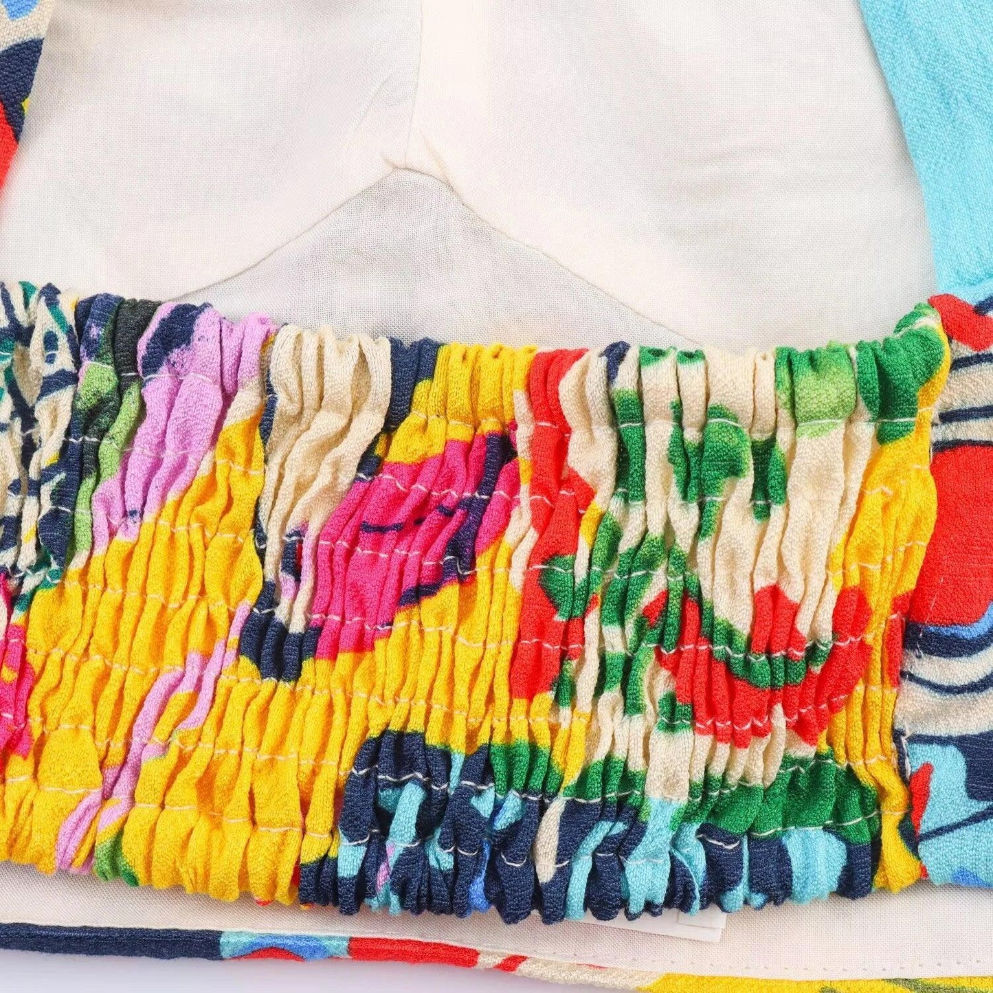 Colorful smocked women's top with vibrant abstract print and elasticated detail