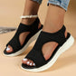 Black knit open-toe sandals with white platform sole, worn with denim shorts and white nail polish