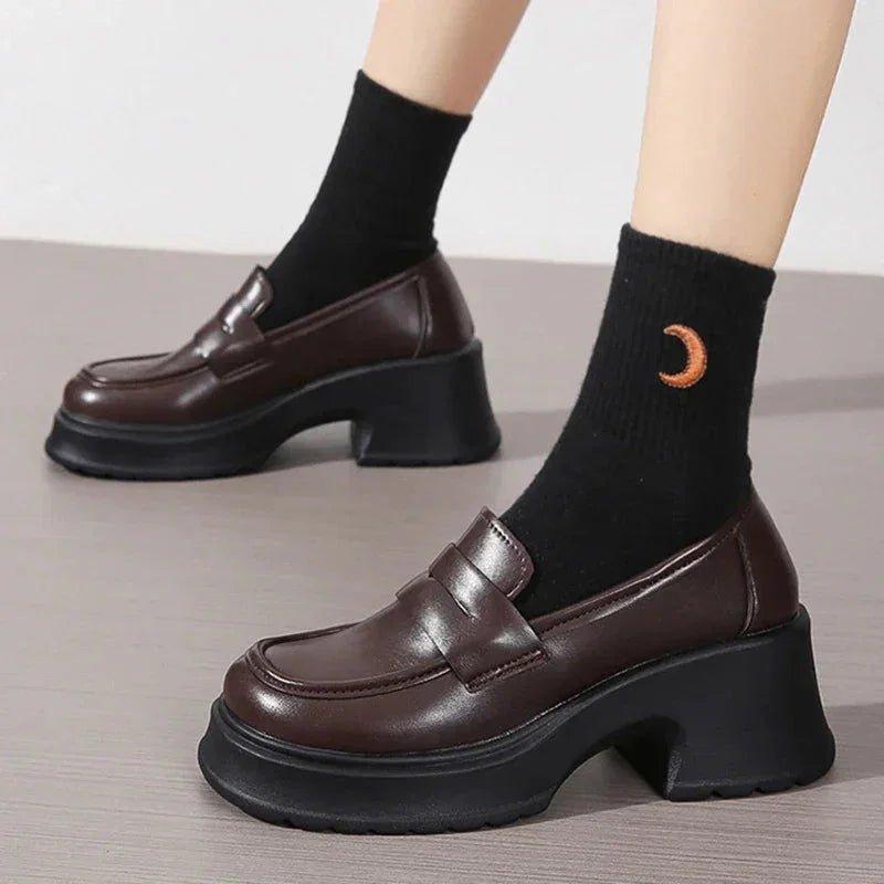 Brown platform loafers with chunky heels, paired with black socks featuring a moon design, ideal for women's fashion.