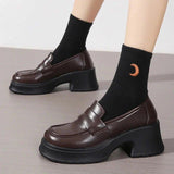 Brown platform loafers with chunky heels, paired with black socks featuring a moon design, ideal for women's fashion.