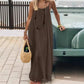 Woman in olive green maxi dress with straw bag, standing by vintage car, summer fashion