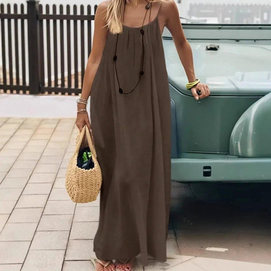 Woman in olive green maxi dress with straw bag, standing by vintage car, summer fashion