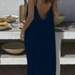 Woman in navy blue backless maxi dress at outdoor table, summer fashion style
