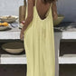 Woman in backless yellow summer dress at outdoor table with fruit bowls
