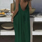 Woman in green backless maxi dress at outdoor table with fruit bowls