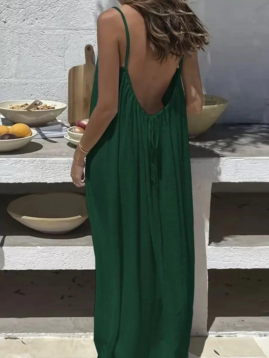 Woman in green backless maxi dress at outdoor table with fruit bowls