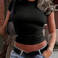 Woman in black ribbed crop top and low-rise jeans, stylish streetwear fashion