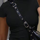 Woman in black fitted tee with studded navy crossbody bag, fashion accessory