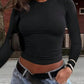 Woman wearing black long sleeve crop top with jeans and belt, stylish street fashion outfit