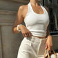 Woman in white ribbed halter top and high-waist pants, stylish summer fashion outfit