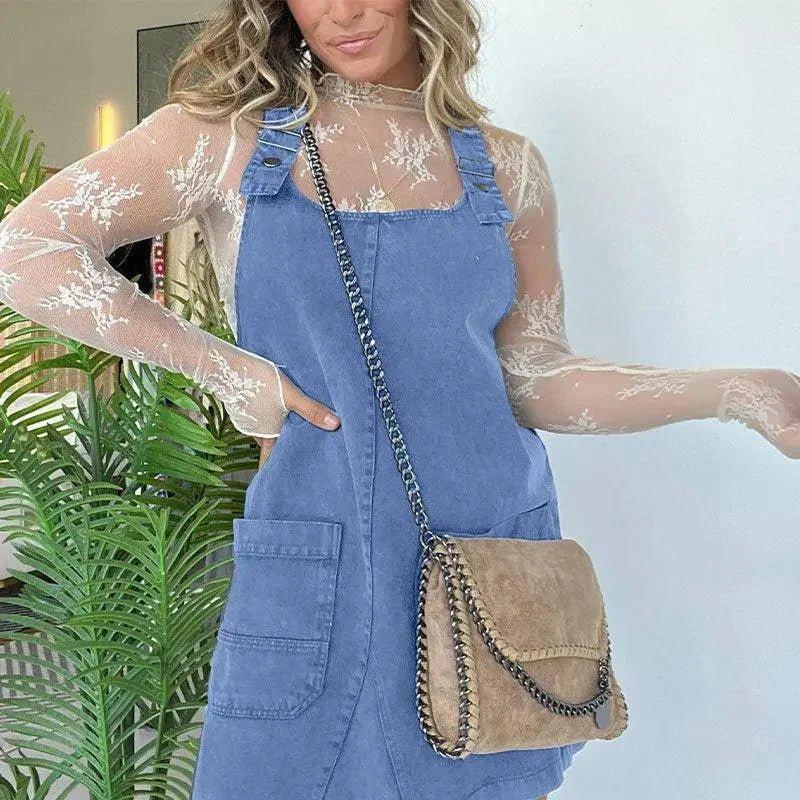 Woman in blue denim overall dress with lace top and chain strap bag, stylish fashion outfit