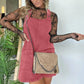 Woman in pink corduroy overall dress with lace top and chain strap bag, fashion outfit
