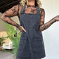 Woman in black lace top and denim overall dress, stylish fashion outfit