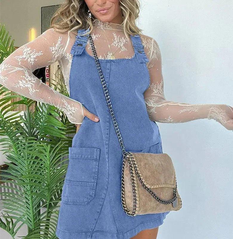Woman in blue denim overall dress with lace top and chain strap bag, fashion outfit